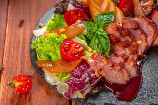 Вкусная нарезанная грудь жареной утки со свежим овощным салатом крупным планом на тарелке. — стоковое фото