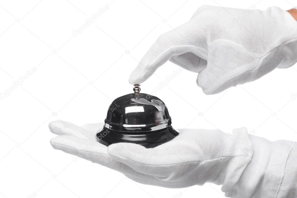 First-class service. Hand in white gloves holding hotel bell