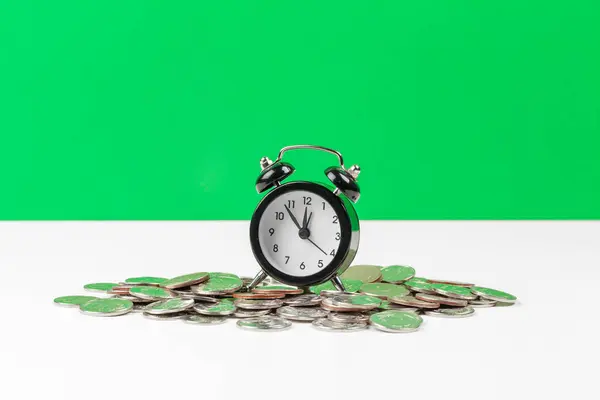 Reloj despertador y monedas de dinero sobre la mesa. foto creativa . — Foto de Stock