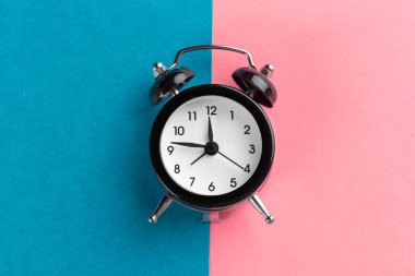 Renk bloğu arka planında klasik siyah alarm saati