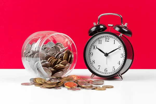 Reloj despertador y monedas de dinero sobre la mesa. — Foto de Stock