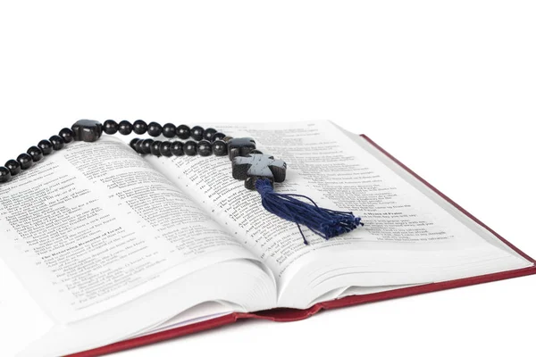 La Biblia sobre un fondo blanco. Libro sagrado y rosario de madera . — Foto de Stock