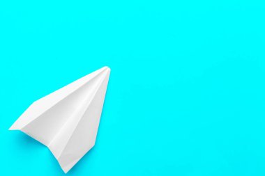 Beyaz kağıt uçağın düz yatağı ve pastel mavi arkaplan üzerine boş kağıt