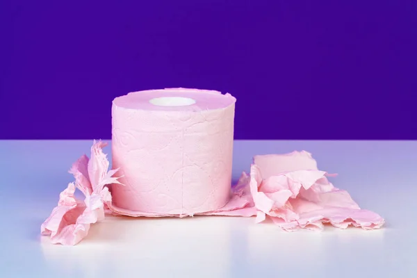 Rollos de papel higiénico aislados sobre mesa blanca con fondo púrpura — Foto de Stock