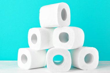 Turkuazın parlak arka planında tuvalet kağıdı ruloları