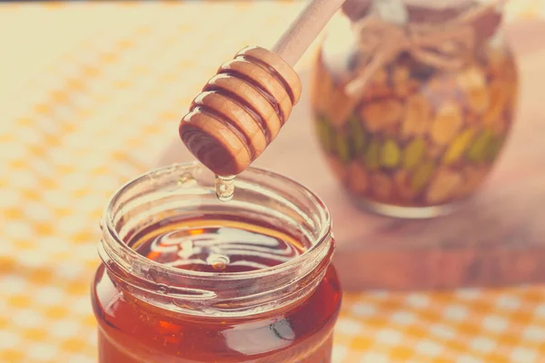 Tło miodu. Słodki miód w szklanym słoiku na drewnianym tle. — Zdjęcie stockowe