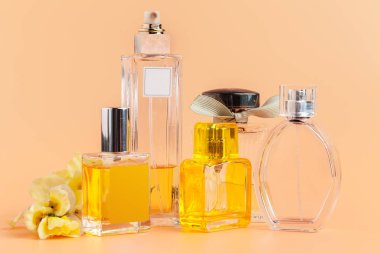 Bej arka planda çiçek yapraklı parfüm şişeleri