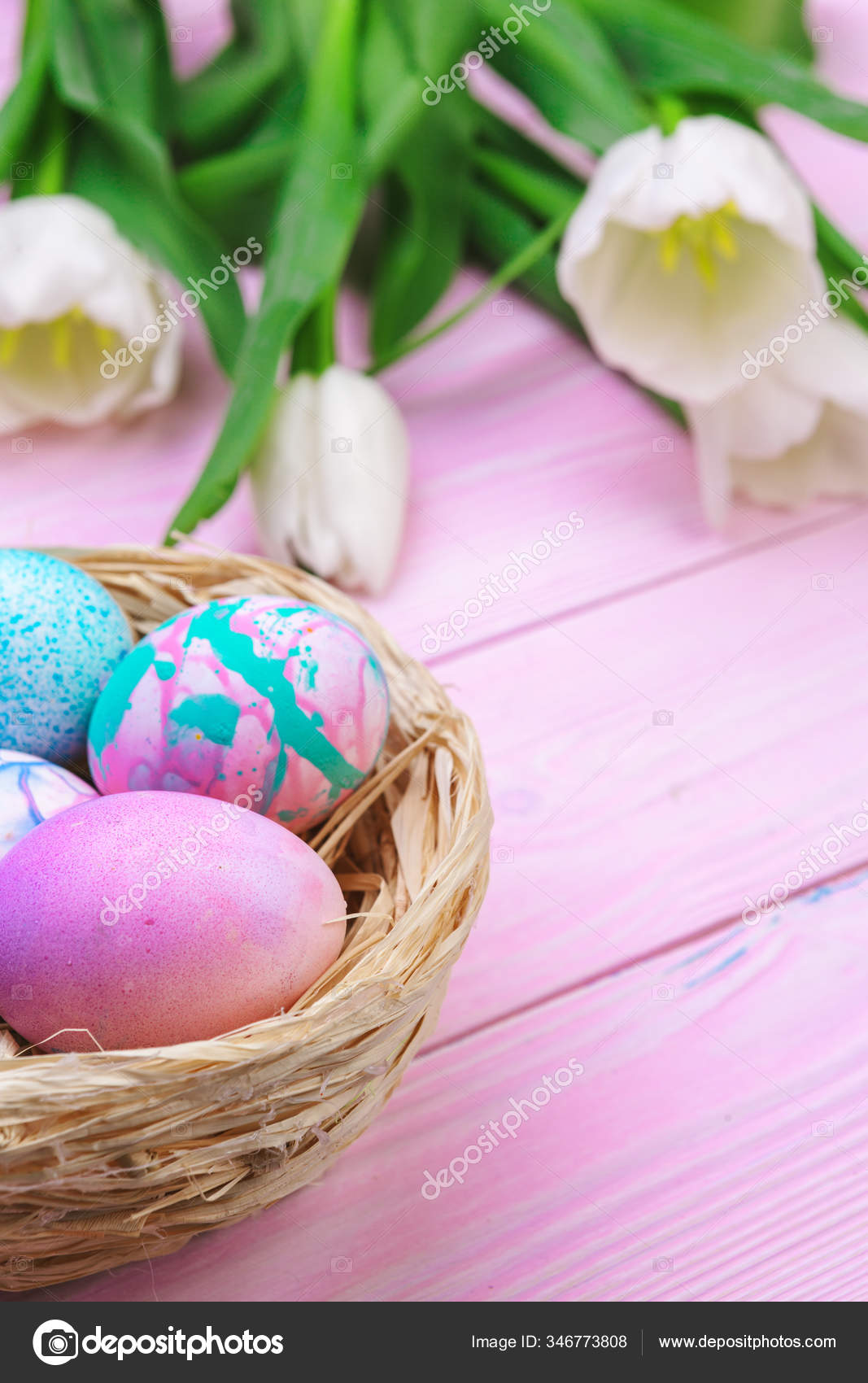 Easter background with colorful eggs and tulips over pink wood. Top