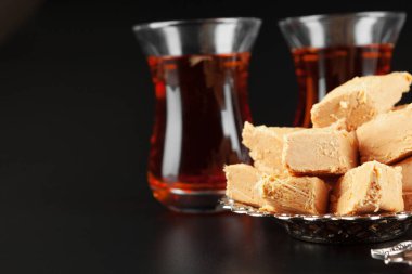 İçinde Türk Lokum ve siyah çay parçaları olan bir kase.