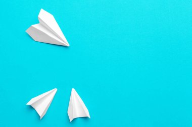 Mavi arka planda beyaz kağıt uçak