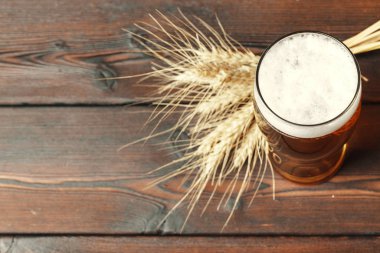 Ahşap arka planda cam bira. Yaratıcı fotoğraf.