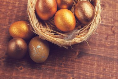 Ahşap arka planda altın Paskalya yumurtaları. Yaratıcı fotoğraf.