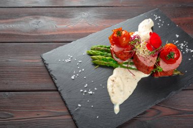 Siyah bulaşık takımında kuşkonmaz ve ahşap masa.