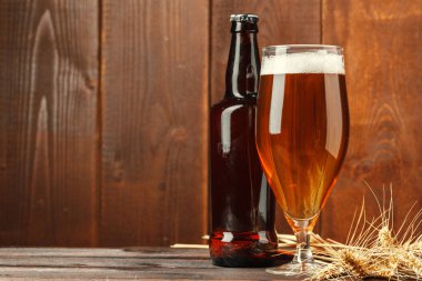 Ahşap arka planda cam bira. Yaratıcı fotoğraf.