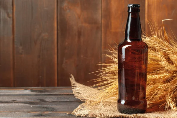 Beer bottle on wooden background. creative photo. — Stock fotografie