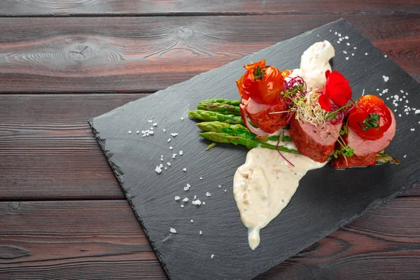 Siyah bulaşık takımında kuşkonmaz ve ahşap masa.