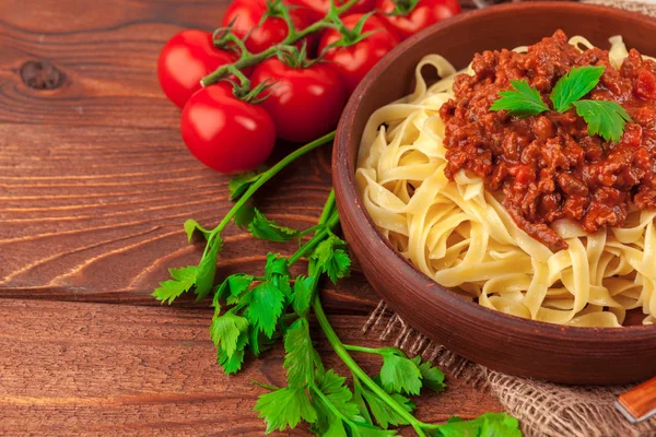 Pasta met vlees, tomatensaus en groenten op tafel — Stockfoto