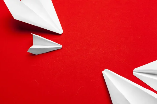 white paper airplane on a red background