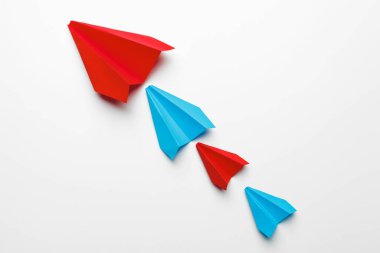 Beyaz arka planda kırmızı ve mavi kağıt uçaklar. Liderlik ve İş Yarışma Kavramları
