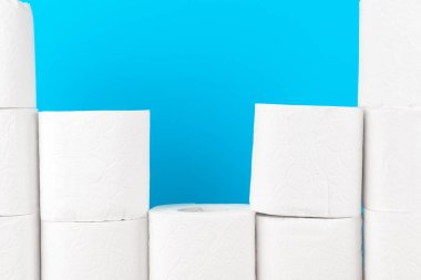 Parlak mavi arkaplanda tuvalet kağıdı yığını
