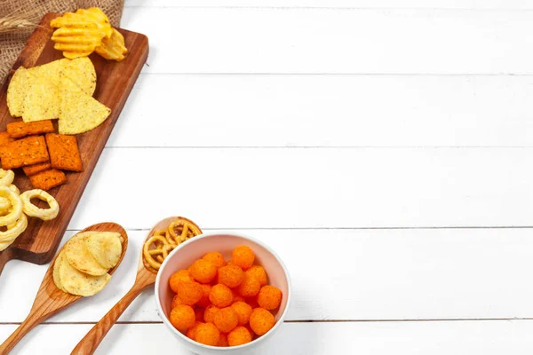 Mezcla de snacks: pretzels, galletas saladas, patatas fritas y nachos sobre la mesa — Foto de Stock