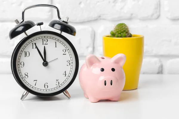 Piggy bank save coin and alarm clock, time and money concept. creative photo.