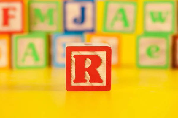 Photograph of colorful Wooden Block Letter R. Creative photo.