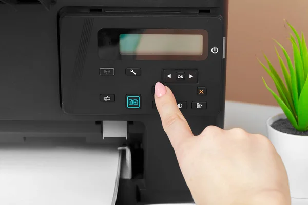 Woman using the printer to scanning and printing document