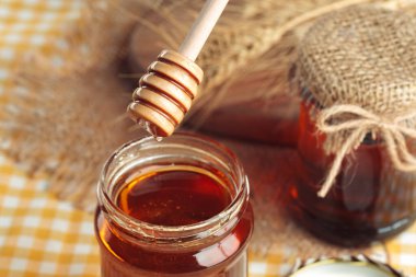 Bal geçmişi. Ahşap arka planda cam kavanozda tatlı bal. yaratıcı fotoğraf.