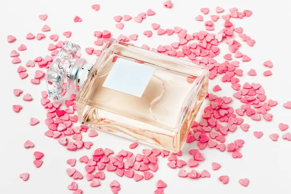 Bottle of perfume with red hearts. creative photo. — Stock Photo, Image