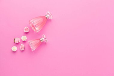 Pembe arka planda parfüm şişeleri. yaratıcı fotoğraf.