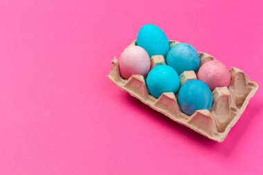 Pembe arka plan üzerinde renkli paskalya boyalı yumurta