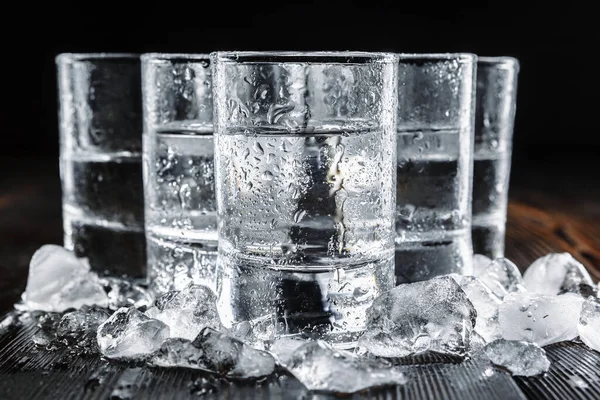 Vodka in shot glasses on rustic wood background. creative photo. — Stock Photo, Image