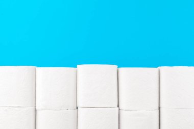 Parlak mavi arkaplanda tuvalet kağıdı yığını