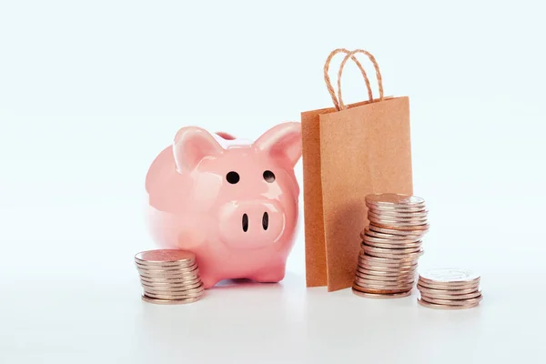 Roze spaarvarken en munten geïsoleerd op wit. Creatieve foto. — Stockfoto