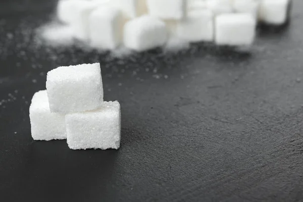 Белый сахар кубики на черном фоне близко — стоковое фото