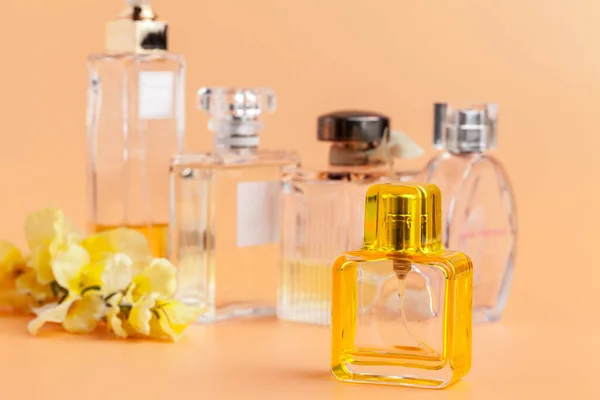 Parfümflaschen mit Blütenblättern auf beigem Hintergrund — Stockfoto
