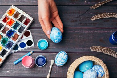 Paskalya yumurtalarını boyayan kadın eller. Yaratıcı fotoğraf.