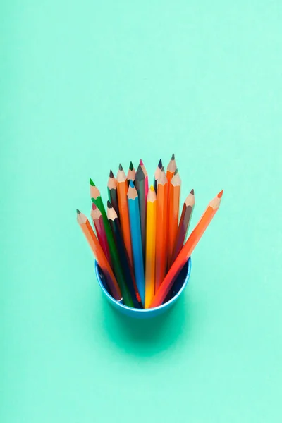 Colorful pencils in a cup on blue background top view — Stock Photo, Image