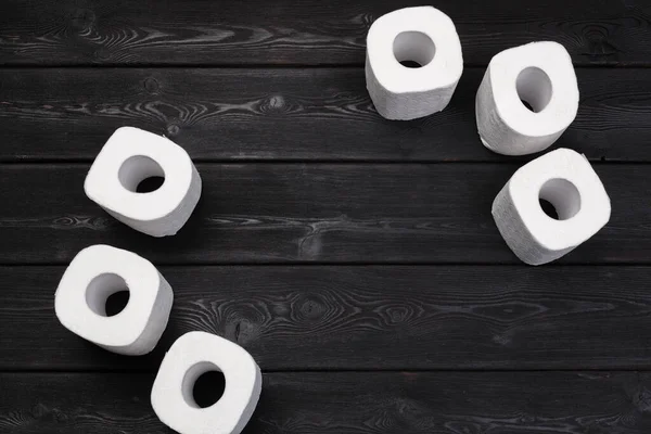 Білий туалет паперові рулони на чорному дерев'яному фоні — стокове фото