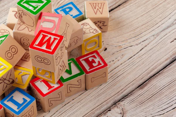Різнокольорові дерев'яні іграшкові блоки на дерев'яному фоні — стокове фото