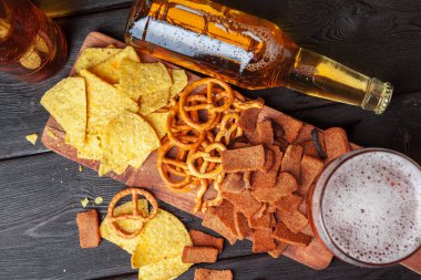 Ahşap arka planda cam bira ve aperatifler