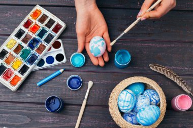 Paskalya yumurtalarını boyayan kadın eller. Yaratıcı fotoğraf.