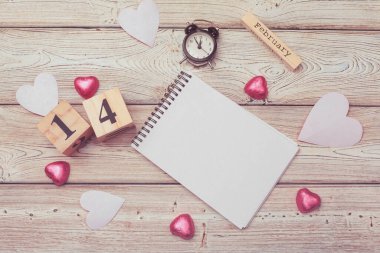 Sevgililer Günü geçmişi. Boş boş defter, hediye kutusu, beyaz arkaplanda çiçekler, üst görünüm.