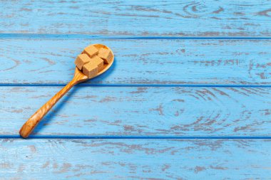 Kahverengi kamış şeker küpleri mavi ahşap arka planda