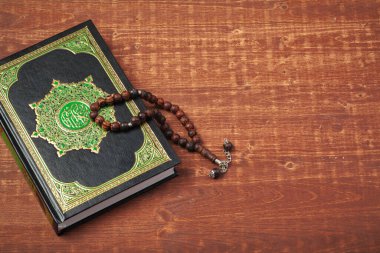 Üç aydır. Tespih boncuklu İslam Kutsal Kitap Kuran 'ı. Ramazan konsepti. Yaratıcı fotoğraf.
