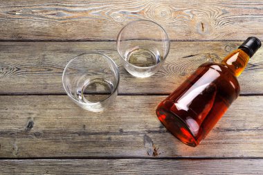 Viski şişesi koyu ahşap arka planda düz yatıyordu.