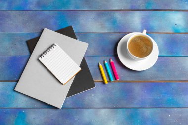 Kontrol listesi için model, mavi ahşap arka planda kahve fincanı olan boş not kağıdı. Ofis, yazar veya öğrenim kavramı