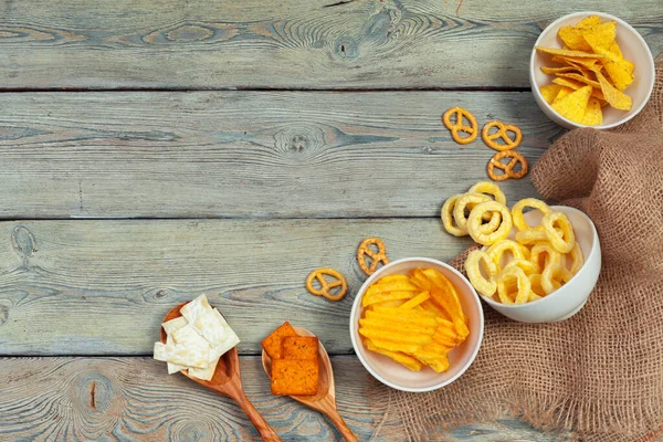 Mezcla de snacks: pretzels, galletas saladas, papas fritas y nachos sobre la mesa. foto creativa . — Foto de Stock