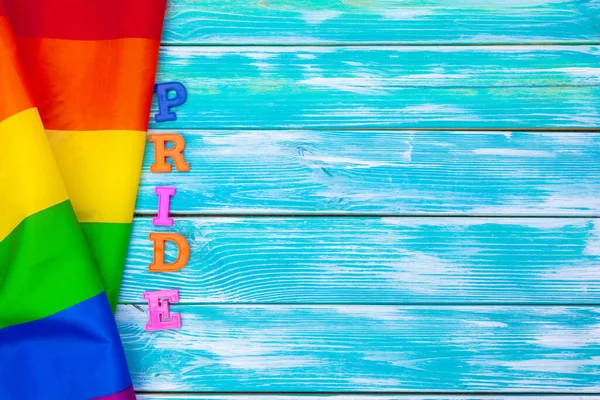 Tahta masada eşcinsel gururu bayrağı. yaratıcı fotoğraf. — Stok fotoğraf